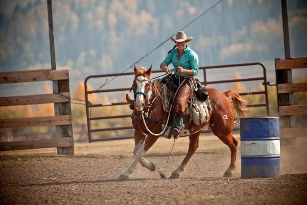 cowgirl aan het paardrijden op Goosewing Ranch in Wyoming