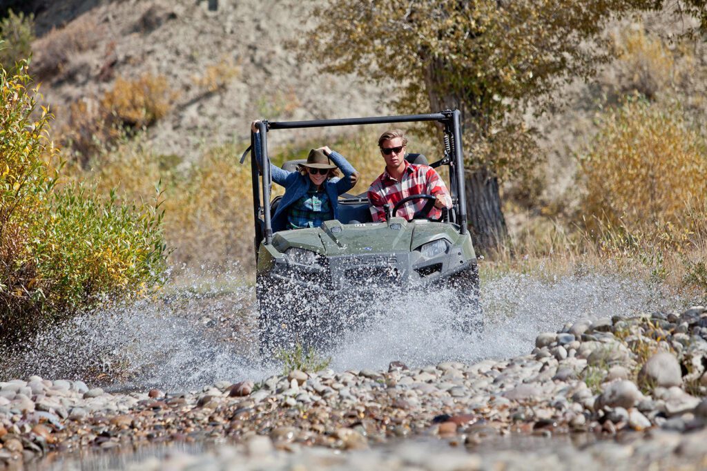 avontuurlijk rijden met een UTV (utility terrain vehicle) dat door water rijdt