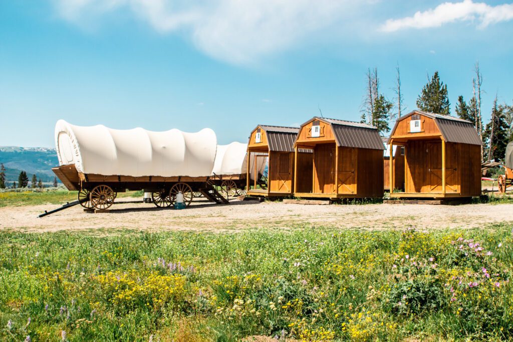 huifkar voor drie houten huisjes op Goosewing Ranch in Wyoming